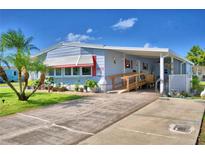 Cute Florida mobile home with carport, ramp, and landscaped yard at 5002 Lodgewood Dr, Lakeland, FL 33810