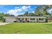 Ranch-style home with brick facade, attached garage, and spacious lawn at 1175 E George St, Bartow, FL 33830