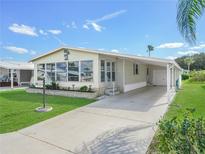 Light beige manufactured home with carport at 134 Lake Hazel Dr, Winter Haven, FL 33884