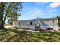 Gray manufactured home with new steps and landscaping at 6193 Doris Rd, Bartow, FL 33830