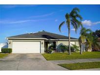 Single-story home with attached garage, palm trees, and manicured lawn at 1015 Highland Crest Cir, Lake Wales, FL 33853
