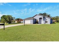 One-story home with a gray exterior and a two-car garage at 6064 Mission Dr, Lakeland, FL 33812