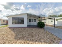 White single-wide manufactured home with covered carport at 6603 Westchester Ne Dr, Winter Haven, FL 33881