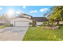 White two-story house with a two-car garage and landscaped lawn at 1215 Cypress E Pt, Winter Haven, FL 33884