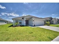 Single-story house with a two-car garage and grassy lawn at 1580 Leamington Ln, Winter Haven, FL 33884