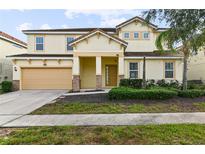 Two-story house with beige siding, a three-car garage, and landscaping at 7004 Oakwood St, Davenport, FL 33837