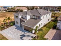Two-story house with gray roof and a gray stone driveway at 1005 Coyote Creek Way, Reunion, FL 34747