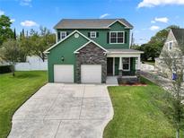 Two-story green house with stone accents and two-car garage at 2731 Coventry Ave, Lakeland, FL 33803