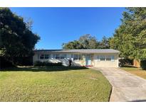 Ranch-style home with light-colored walls, blue shutters, and a well-maintained lawn at 338 Tanager, Lakeland, FL 33803