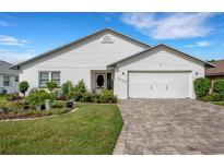 White single-story house with a two-car garage and landscaped front yard at 6250 Sandpipers Dr, Lakeland, FL 33809