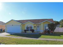 Cute yellow house with a two-car garage and well-manicured lawn at 267 Kings Pond Ave, Winter Haven, FL 33880