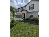 Two-story house with a neutral color scheme, landscaping, and a two-car garage at 2739 Red Egret Dr, Bartow, FL 33830