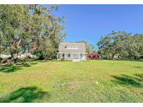 Front view of a charming white farmhouse on a spacious lot at 285 Lemon St, Mulberry, FL 33860