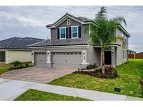 Two-story house with gray siding, two-car garage, and landscaping at 4712 Grandview Glen Dr, Auburndale, FL 33823