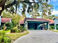 Front view of a condo with carport and well-manicured landscaping at 6718 Trail Ridge Dr, Lakeland, FL 33813