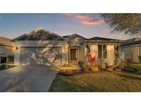 Charming one-story house with gray and beige exterior, landscaping, and a two-car garage at 6799 Glenbrook Dr, Lakeland, FL 33811