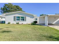 White single story home with carport and green lawn at 718 Barber Cir # 718, Lakeland, FL 33803