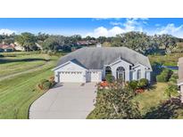 Single-story home with a two-car garage and landscaped yard at 4402 Fairway Oaks Ct, Mulberry, FL 33860