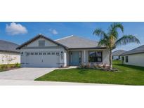 One-story home with gray siding, light gray roof, and a two-car garage at 5114 Villa Crest Way, Auburndale, FL 33823