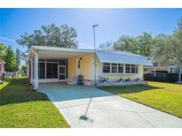 Cute yellow mobile home with carport and landscaped lawn at 1610 Reynolds Rd # 79, Lakeland, FL 33801