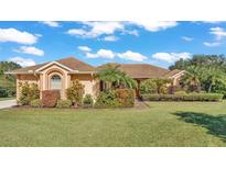 Single-story home with a manicured lawn and lush landscaping at 3206 Heron Cv, Winter Haven, FL 33884