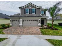 Two-story house with gray siding, tile roof, and a two-car garage at 4443 Juliana Lake Dr, Auburndale, FL 33823