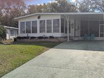 Single-wide manufactured home with carport and mature landscaping at 1610 Reynolds Rd # 211, Lakeland, FL 33801