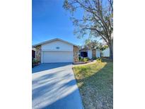 House exterior featuring a two-car garage and well-maintained lawn at 3709 Feather Dr, Lakeland, FL 33812