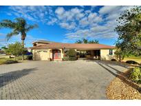 Attractive single-story home with paver driveway and covered entryway at 561 Meandering Way, Polk City, FL 33868
