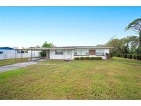 Ranch-style home with carport and spacious lawn at 1568 S Lake Shipp Dr, Winter Haven, FL 33880