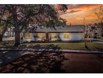 Charming bungalow with a white exterior, manicured lawn, and brick driveway at 425 E Belmar St, Lakeland, FL 33803
