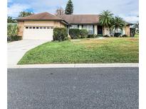 Single-story house with attached garage, landscaping, and a palm tree at 5805 Danterbury Ct, Lakeland, FL 33810