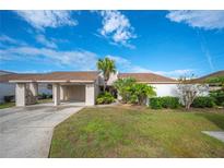 Tan two-story home with carport and landscaped yard at 4241 Oak Loop # 36, Mulberry, FL 33860