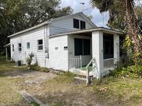 White single story house with porch and mature trees at 142 Park Blvd, New Smyrna Beach, FL 32168