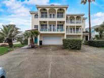 Three-story house with double garage and arched balconies at 610 S Atlantic Ave, New Smyrna Beach, FL 32169