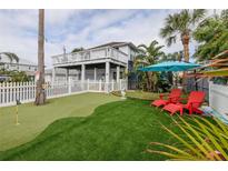 Private backyard oasis with putting green, lounge chairs, and a patio at 830 Maralyn Ave, New Smyrna Beach, FL 32169