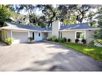 Charming house with gray siding, a two-car garage, and landscaped yard at 411 Wildwood Dr, New Smyrna Beach, FL 32168