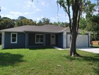 Newly built home with blue exterior and white garage at 181 N Putnam Grove Rd, Oak Hill, FL 32759