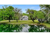 Two story house with a pond and lush green landscape at 1795 Hideaway Ln, Edgewater, FL 32141