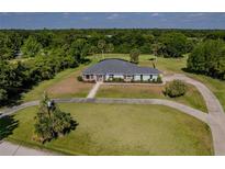 Aerial view of single-story home with large yard and circular driveway at 756 Bay Dr, New Smyrna Beach, FL 32168