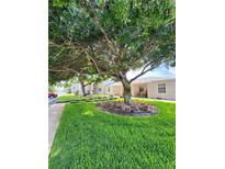 Condo building with mature landscaping and a large tree at 2100 N Peninsula Ave # 1050, New Smyrna Beach, FL 32169