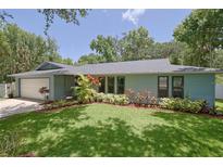 Ranch-style home with a large yard and attached garage at 1319 Orange Tree Dr, Edgewater, FL 32132