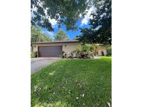 House exterior with a brown garage door and landscaping at 2503 Woodland Dr, Edgewater, FL 32141