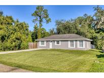 Newly constructed grey house with white accents, and a grassy lawn at 1004 W 7Th St, New Smyrna Beach, FL 32168