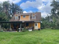 Yellow house with a covered patio and large backyard at 1728 Elizabeth St, New Smyrna Beach, FL 32168