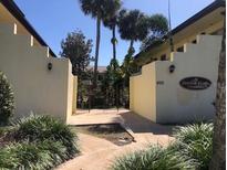 Building entrance with a wrought iron gate and landscaping at 400 Oakridge Blvd # 6, Daytona Beach, FL 32118