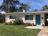 Charming Ranch style home with teal door and landscaped yard at 113 Neptune Dr, Edgewater, FL 32132