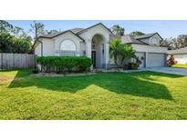 Two-story house with a three-car garage, manicured lawn, and landscaping at 510 Sun Lake Dr, Port Orange, FL 32127