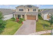 Two-story house with solar panels, paver driveway and landscaped yard at 2305 Santa Rosa Ct, Port Orange, FL 32128