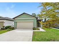 House exterior, two-car garage, and landscaped lawn at 2352 Litchfield Loop, Deland, FL 32720